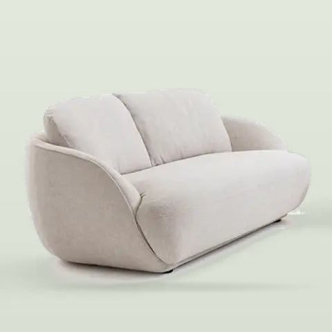 The bench sofa from a three-quarter angle, showing the low rounded arm and the piped seat edge, on a pale sage background