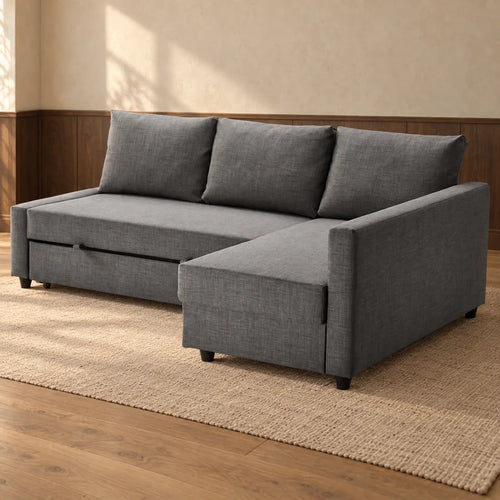 The dark grey corner sofa bed on a jute rug in a room with cream walls, walnut panelling and oak floorboards