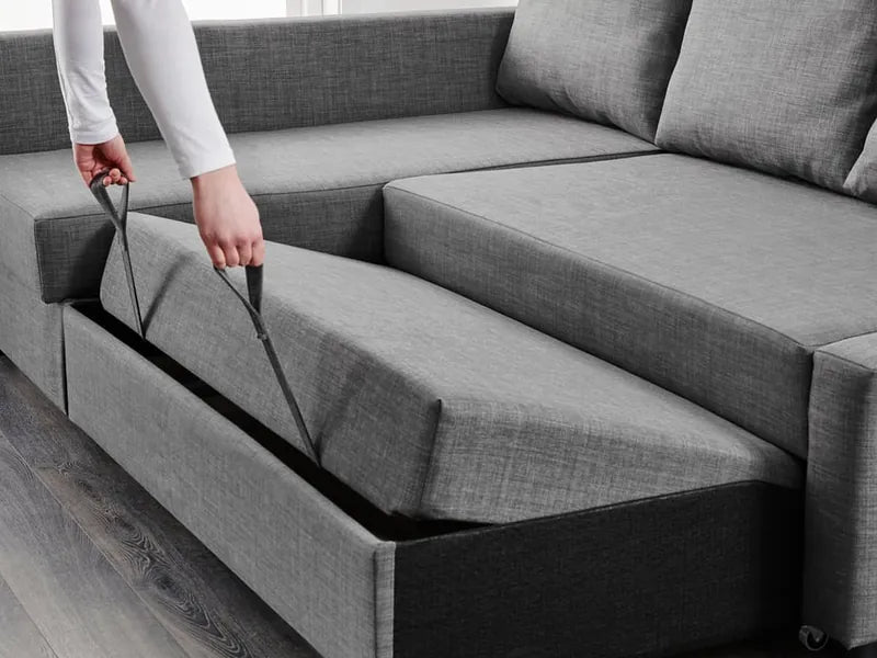 Hands pulling the strap to slide out the bed base of the grey corner sofa bed