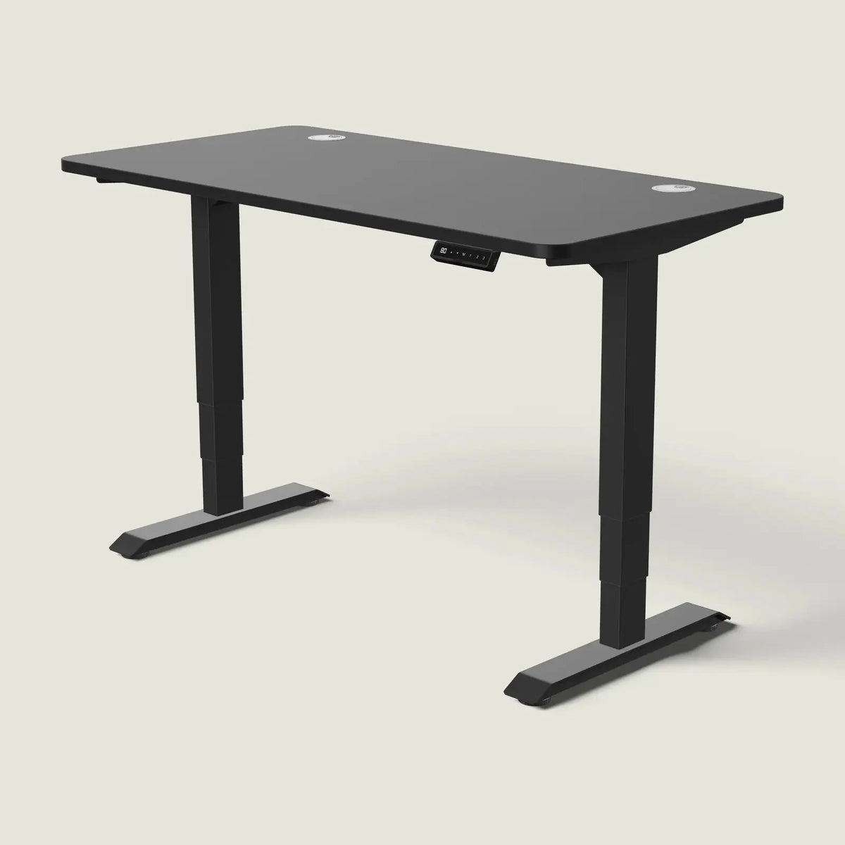 Electric standing desk, 140 × 70 cm, black frame and black top, with the memory handset under the front edge, on a pale grey background